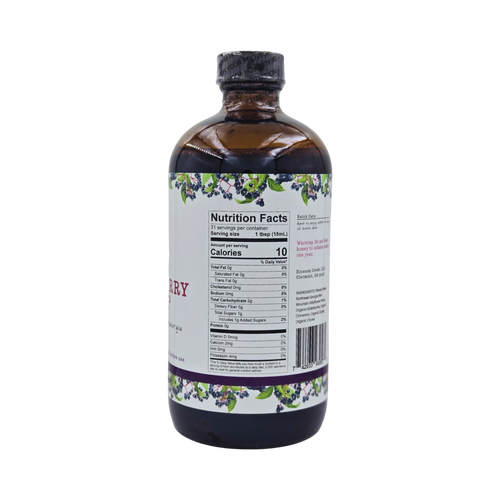 Side view of Blossom Creek 16 oz Elderberry Syrup in an amber glass bottle, featuring the white label with purple and green elderberry illustrations and Nutrition Facts panel.