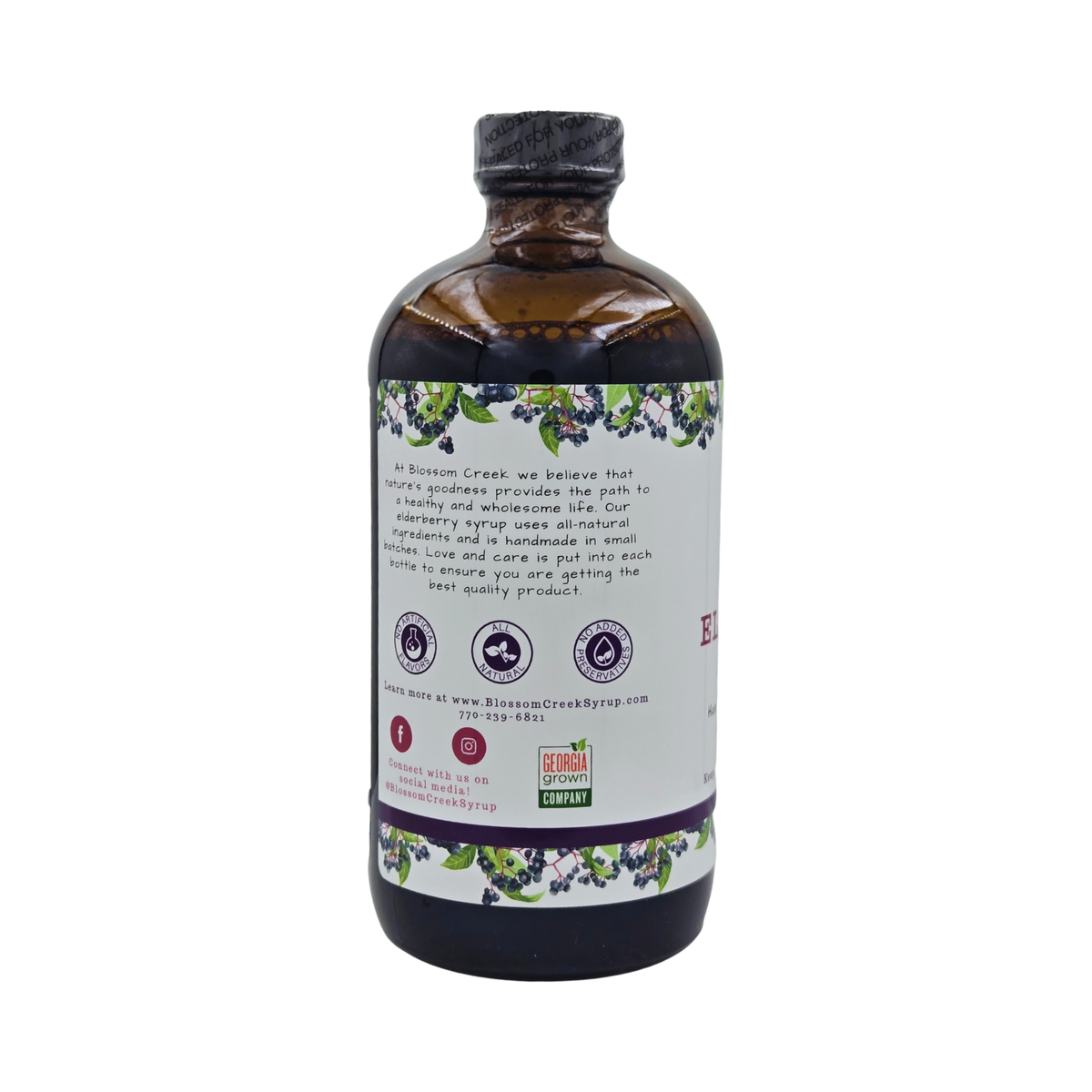 Side view of Blossom Creek 16 oz Elderberry Syrup in an amber glass bottle, featuring the white label with our company story, purple elderberry illustrations, and Georgia Grown logo.