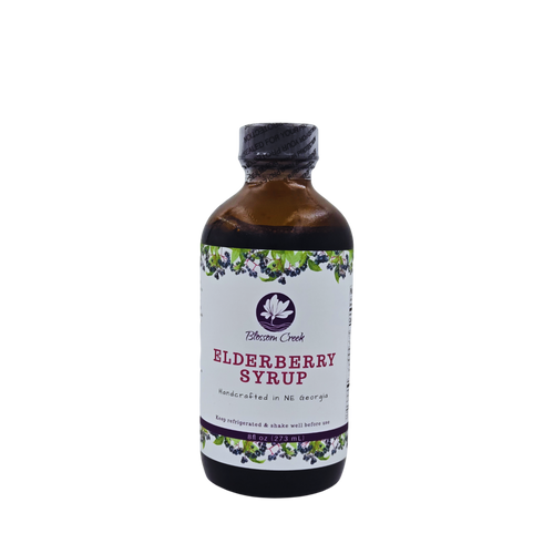 Front view of Blossom Creek 8 oz handcrafted Elderberry Syrup in an amber glass bottle with a white floral and elderberry label, made in North Georgia.