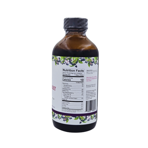 Side view of Blossom Creek 8 oz Elderberry Syrup in an amber glass bottle, featuring a white label with purple and green elderberry illustrations and the Nutrition Facts panel.
