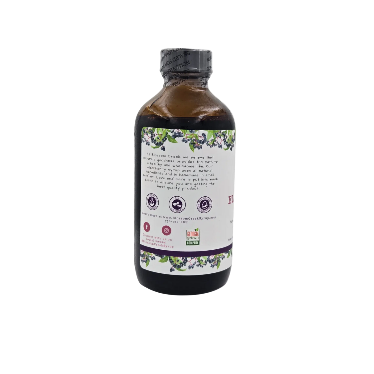 Side view of Blossom Creek 8 oz Elderberry Syrup in an amber glass bottle, featuring the white label with our company story, purple elderberry illustrations, and Georgia Grown logo.